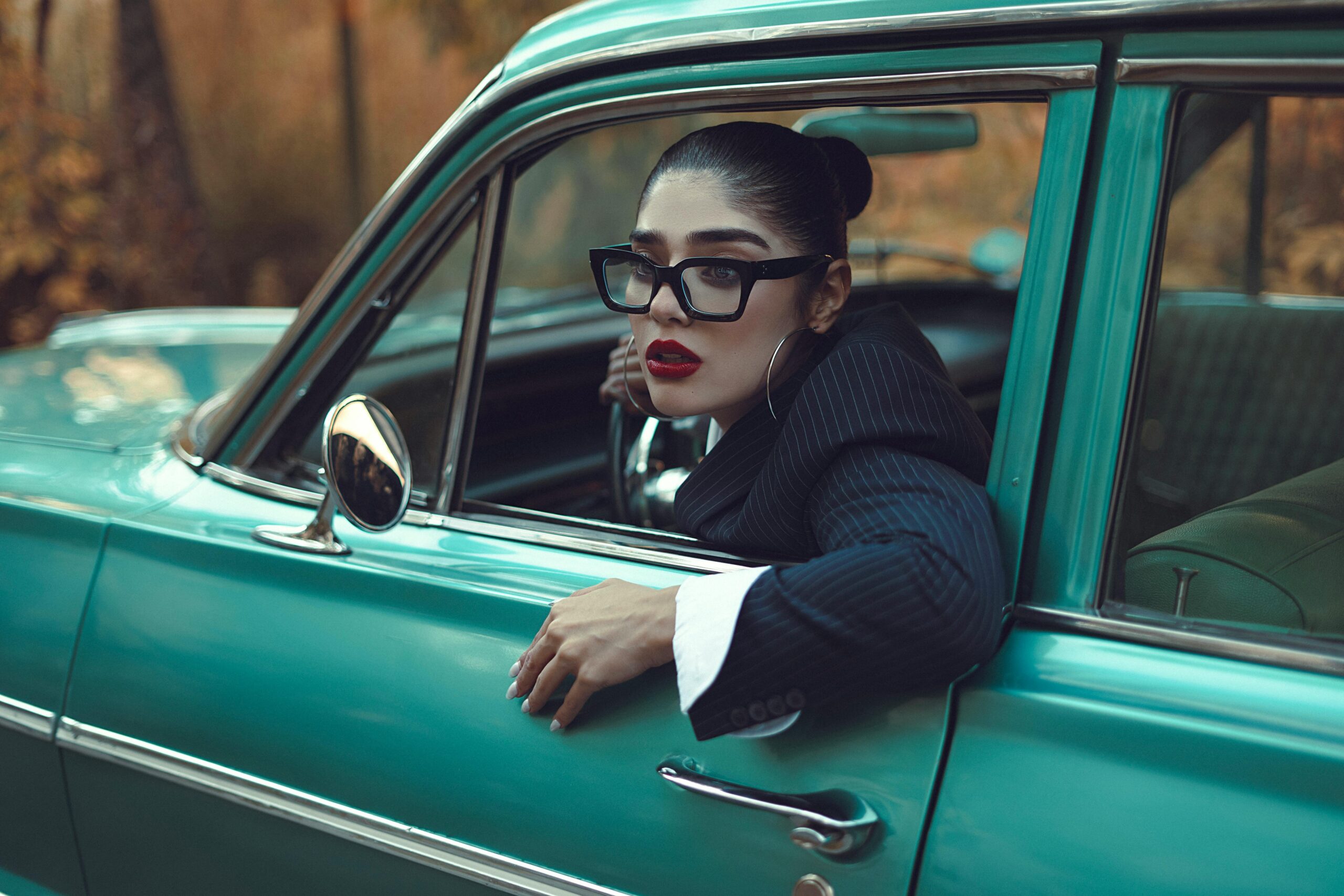 Stilvolle Frau im Oldtimer strahlt Eleganz und Kultiviertheit aus.